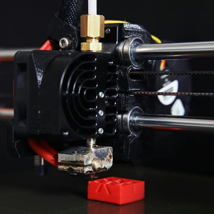 Nahaufnahme Extruder beim Druck eines roten Teils